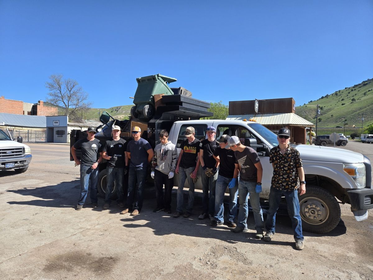 students standing in front of loaded truck after cleanup project